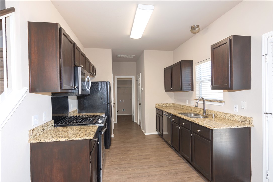 2605 Summerwalk Place Round Rock, TX 78665 - Photo 14 of 37 a kitchen with stainless steel appliances granite countertop a stove refrigerator sink and microwave