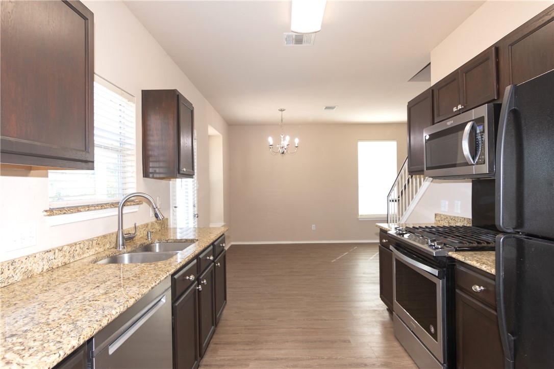 2605 Summerwalk Place Round Rock, TX 78665 - Photo 15 of 37 a kitchen with stainless steel appliances granite countertop a sink stove and refrigerator