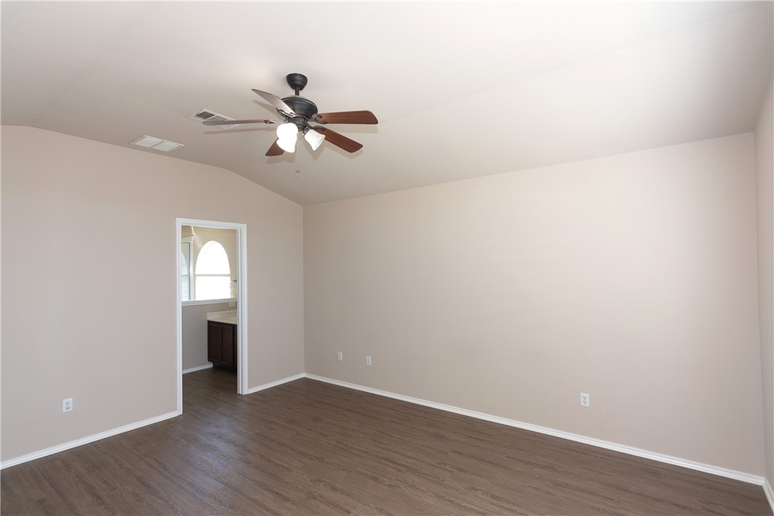 2605 Summerwalk Place Round Rock, TX 78665 - Photo 19 of 37 a view of an empty room with wooden floor and a ceiling fan