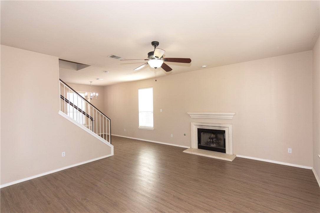2605 Summerwalk Place Round Rock, TX 78665 - Photo 9 of 37 a view of an empty room with wooden floor fireplace and a window
