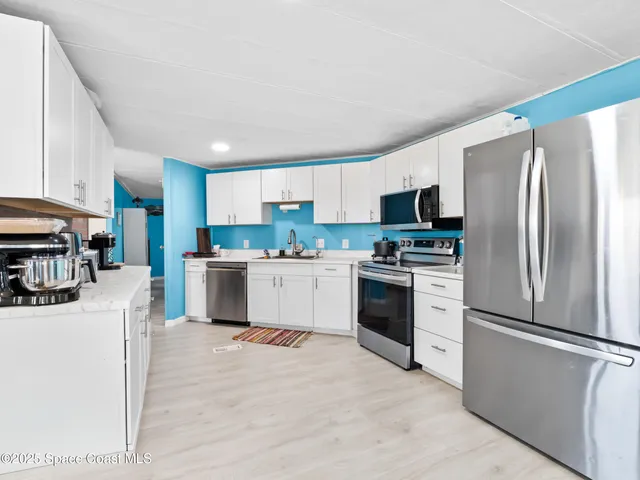 a kitchen with stainless steel appliances granite countertop a refrigerator stove microwave and sink