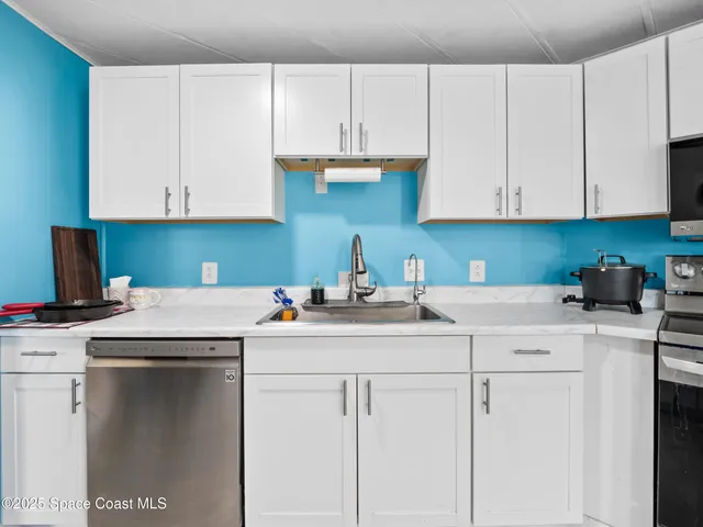 a kitchen with cabinets appliances a sink and a counter top