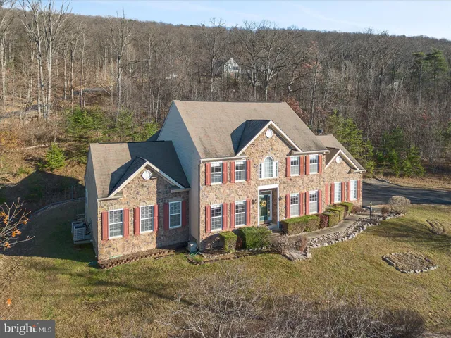 a view of a big house with a big yard and large tree