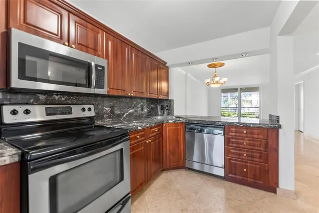 a kitchen with stainless steel appliances granite countertop a stove microwave and sink