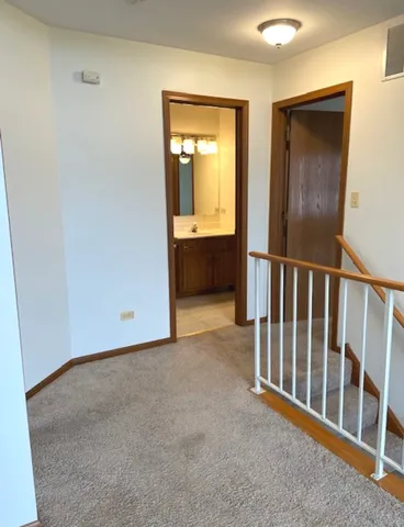 a view of a hallway with wooden floor and stairs