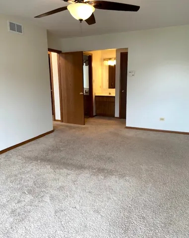 an empty room with a window and a kitchen