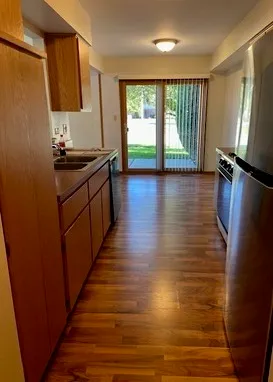 a kitchen with counter top space and wooden floor