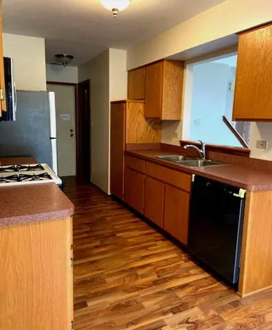 a kitchen with stainless steel appliances granite countertop a sink and a stove top oven