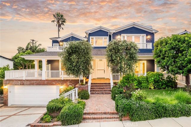 a front view of a house with a yard and trees