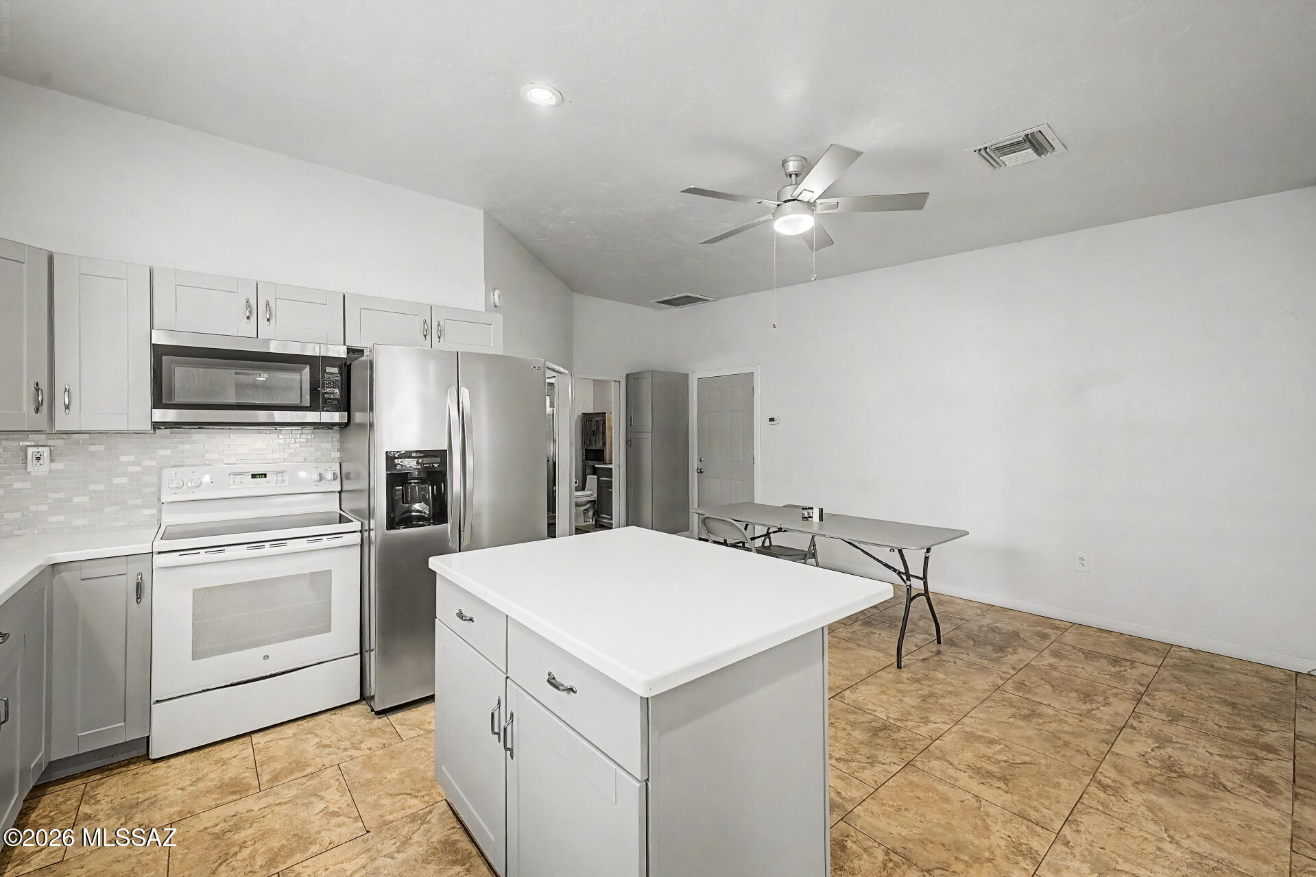4231 East Pinal Street Tucson, AZ 85739 - Photo 31 of 36 a kitchen with kitchen island a stove a sink and a refrigerator