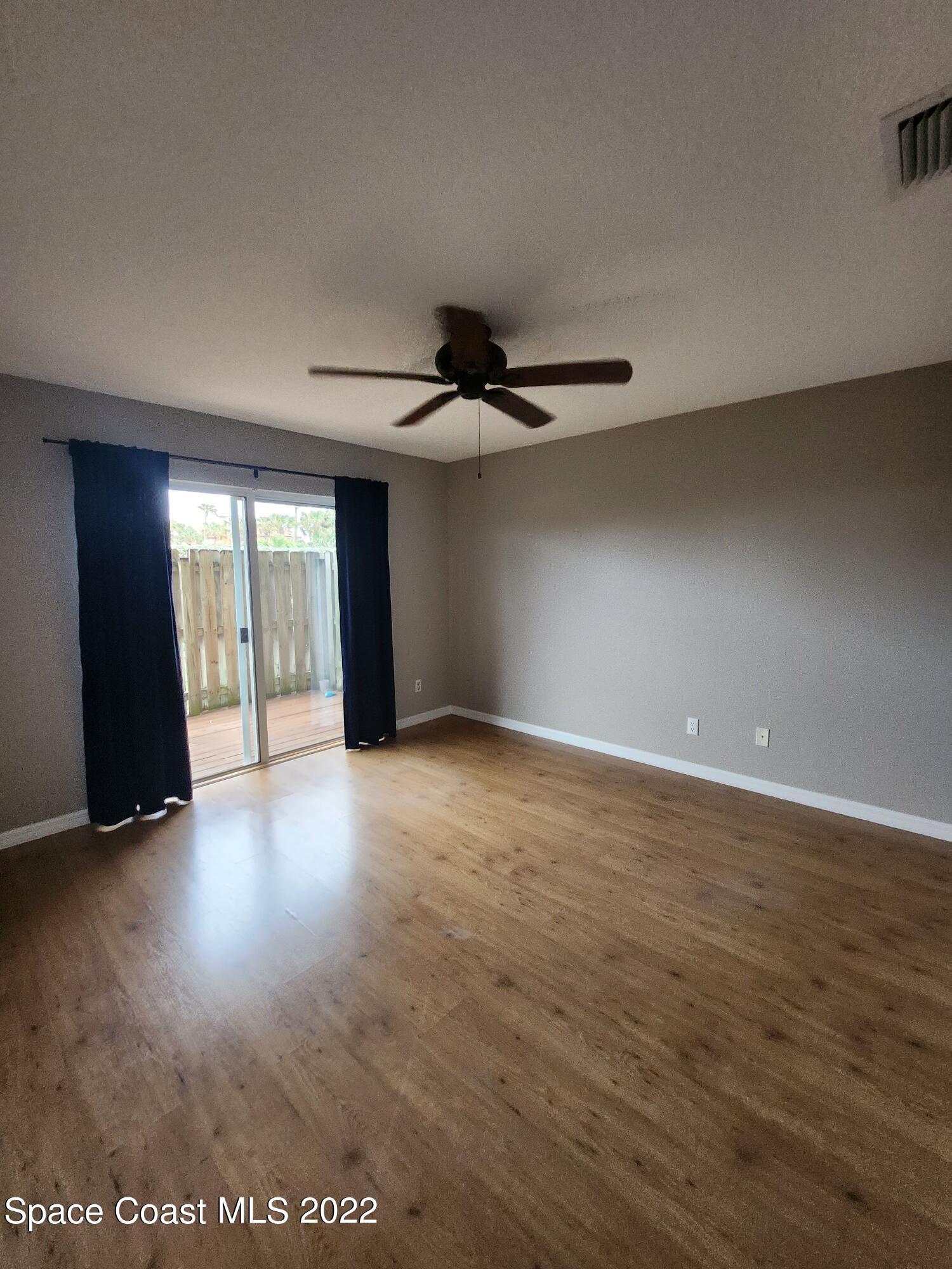 1953 Cato Court, Unit 6 Indialantic, FL 32903 - Photo 9 of 18 a view of an empty room with wooden floor and a window
