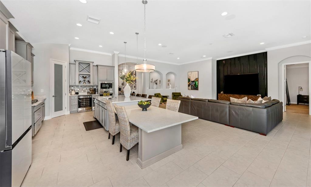 6916 Neopolitan Court Apollo Beach, FL 33572 - Photo 11 of 43 a large living room with stainless steel appliances kitchen island granite countertop couches and a flat screen tv