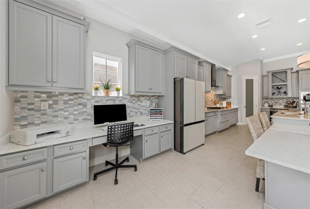 6916 Neopolitan Court Apollo Beach, FL 33572 - Photo 13 of 43 a kitchen with a refrigerator a stove a sink cabinets and a dining table