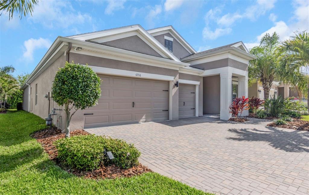 6916 Neopolitan Court Apollo Beach, FL 33572 - Photo 2 of 43 a front view of a house with garden