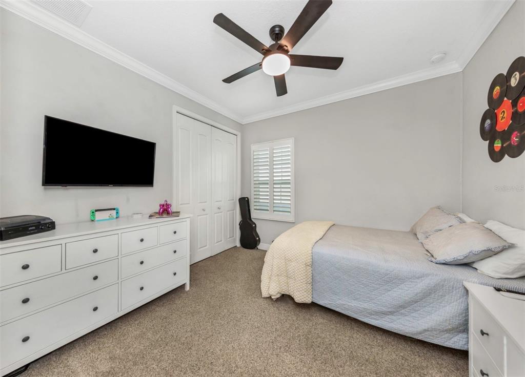 6916 Neopolitan Court Apollo Beach, FL 33572 - Photo 28 of 43 a bedroom with bed tv and furniture