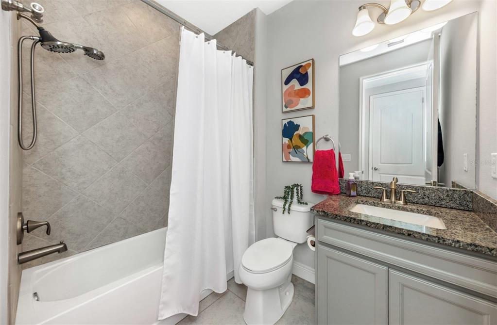 6916 Neopolitan Court Apollo Beach, FL 33572 - Photo 30 of 43 a bathroom with a granite countertop toilet sink and a bathtub