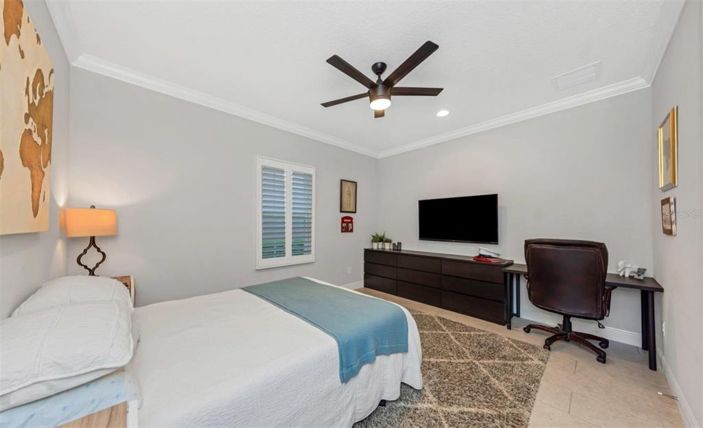 6916 Neopolitan Court Apollo Beach, FL 33572 - Photo 32 of 43 a bedroom with a bed and a flat screen tv