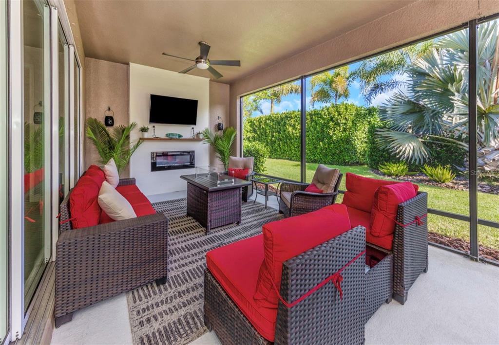 6916 Neopolitan Court Apollo Beach, FL 33572 - Photo 37 of 43 a living room with furniture a flat screen tv and a floor to ceiling window