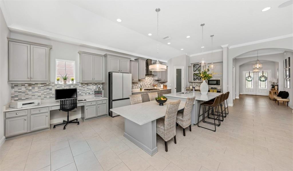 6916 Neopolitan Court Apollo Beach, FL 33572 - Photo 9 of 43 a large kitchen with kitchen island a table chairs sink and refrigerator