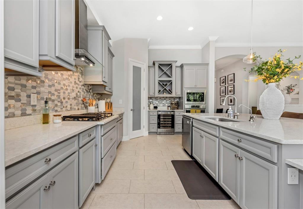 6916 Neopolitan Court Apollo Beach, FL 33572 - Photo 10 of 43 a large kitchen with stainless steel appliances kitchen island granite countertop a sink and cabinets