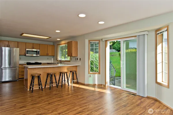 a view of kitchen with granite countertop window and stainless steel appliances