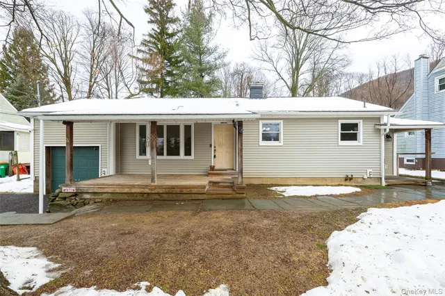 a view of a house with snow on the side of the road