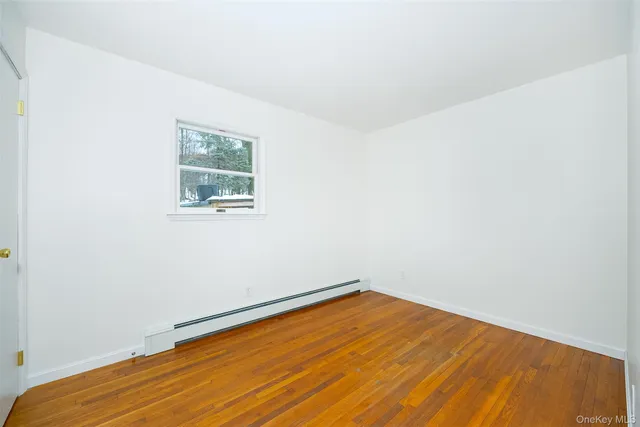 an empty room with a wooden floor and a window