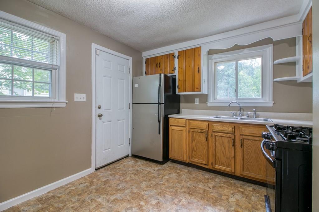 111 Breckwood Boulevard Springfield, MA 01109 - Photo 7 of 25 a kitchen with stainless steel appliances granite countertop a refrigerator a sink a stove a washer and dryer with wooden floor