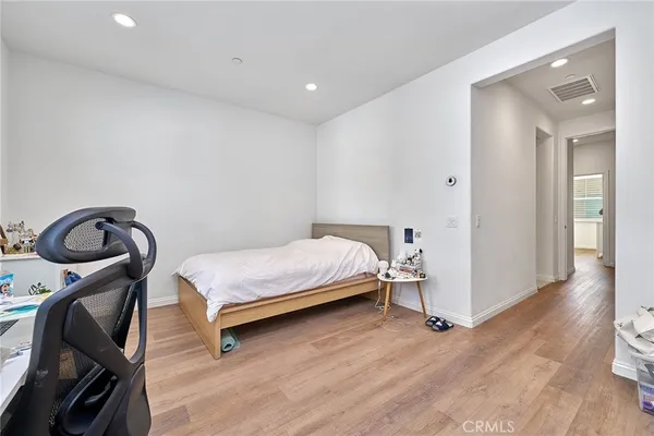 a bedroom with a bed and wooden floor