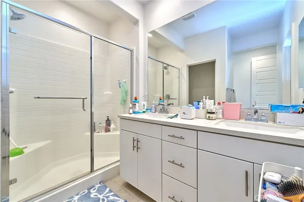 a bathroom with a double vanity sink mirror and shower