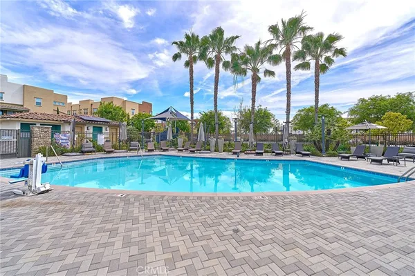 a view of a swimming pool with a lounge chair and palm trees
