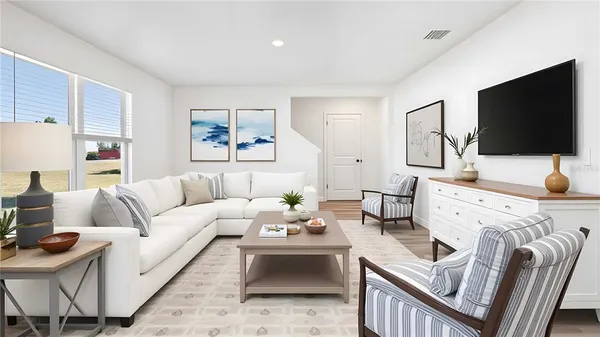 a living room with furniture a flat screen tv and a large window