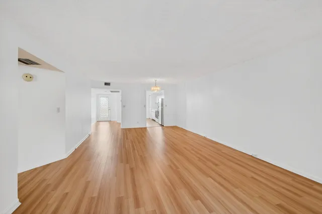 a view of empty room with wooden floor and window