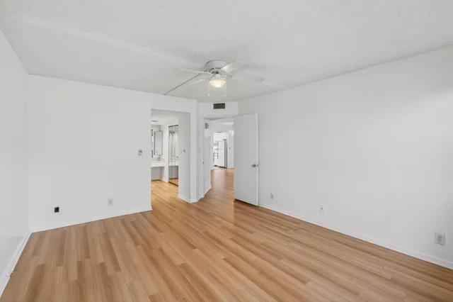 a spacious bathroom with a granite countertop sink toilet a mirror and bathtub