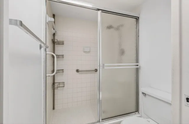 a bathroom with a granite countertop toilet sink and mirror