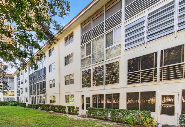 a view of a tennis ground with large trees