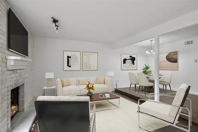 a living room with furniture a flat screen tv and a fireplace