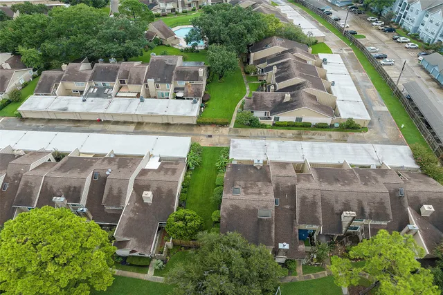 an aerial view of residential houses with outdoor space and swimming pool