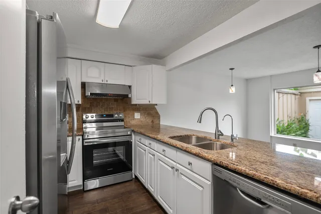 a kitchen with stainless steel appliances granite countertop a sink stove and refrigerator
