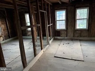 a view of empty room with wooden floor and windows