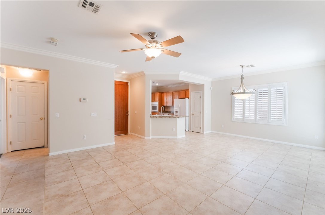 10481 Riverside Park Avenue Las Vegas, NV 89135 - Photo 7 of 51 Unfurnished living room featuring ornamental molding, ceiling fan, and light tile patterned floors