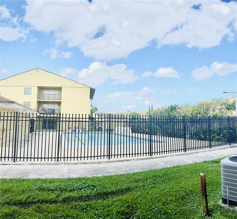a view of a house with a yard and fence