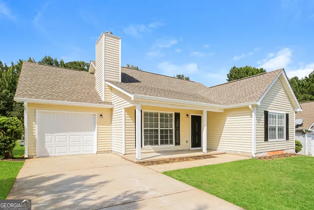 a front view of a house with a garden and yard
