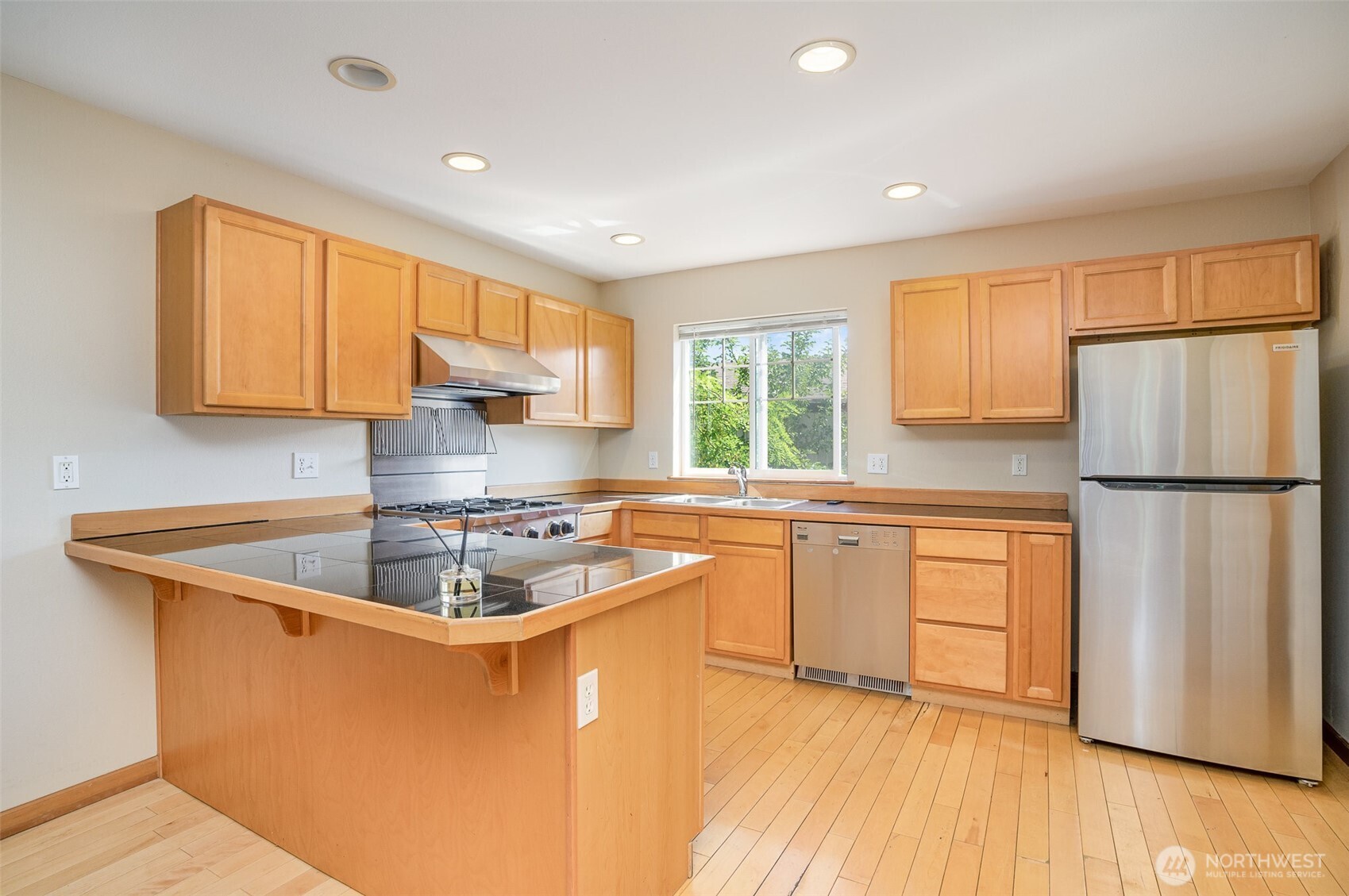 10710 Whitman Avenue North, Unit B Seattle, WA 98133 - Photo 5 of 18 a kitchen with stainless steel appliances granite countertop a sink stove and refrigerator