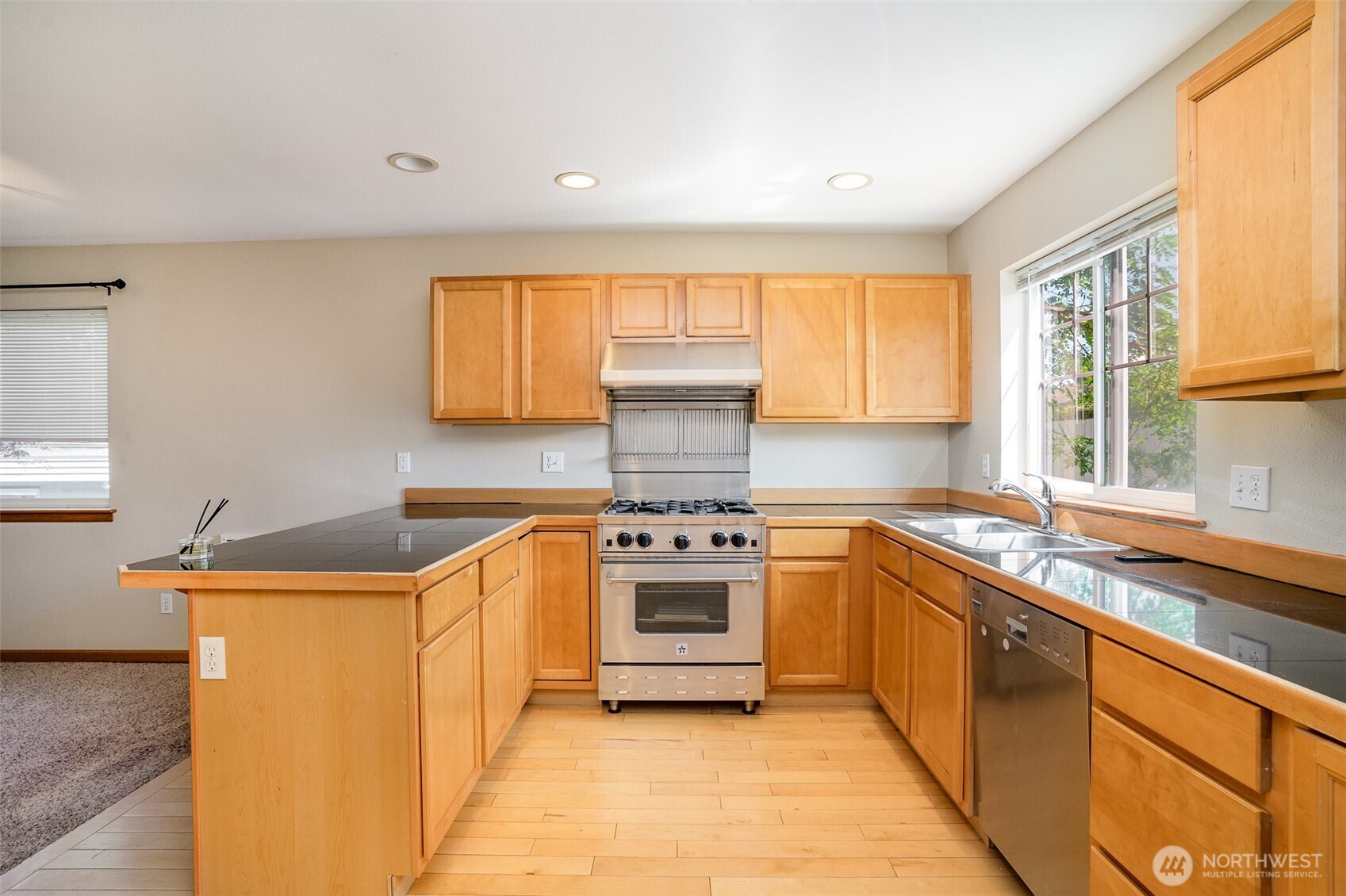 10710 Whitman Avenue North, Unit B Seattle, WA 98133 - Photo 6 of 18 a kitchen with stainless steel appliances granite countertop a sink and a stove