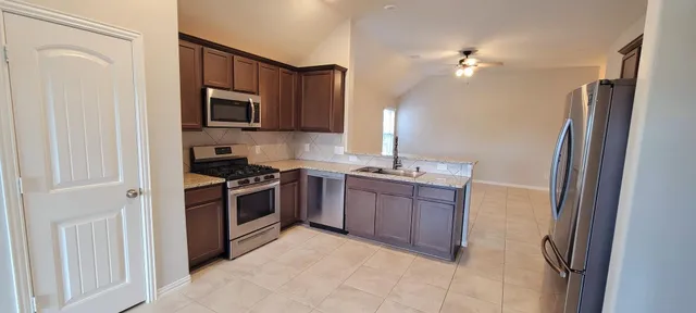 a kitchen with stainless steel appliances granite countertop a refrigerator and a sink