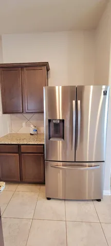 a kitchen with granite countertop a refrigerator and a sink