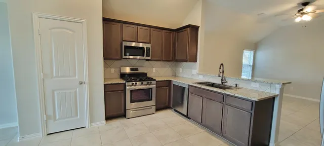 a kitchen with stainless steel appliances granite countertop a sink stove and microwave