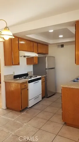 a kitchen with stainless steel appliances granite countertop a sink and a refrigerator