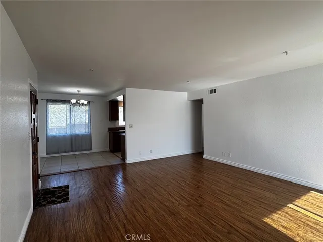 a view of a kitchen with wooden floor and electronic appliances